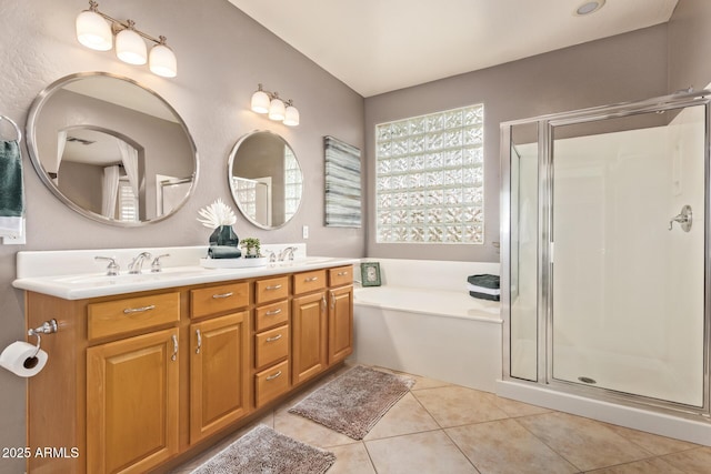 bathroom featuring tile patterned floors, a bath, a stall shower, and a sink