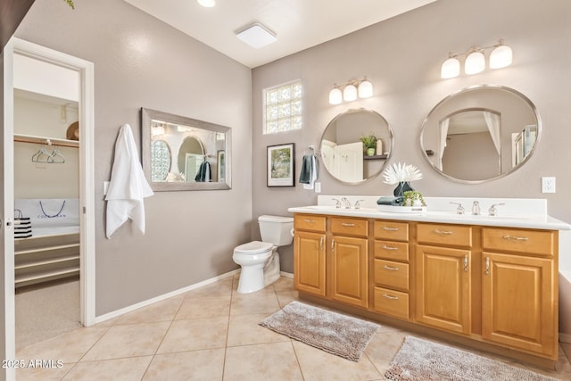 full bathroom featuring toilet, a sink, tile patterned flooring, double vanity, and baseboards