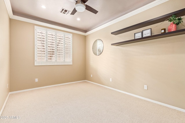 carpeted empty room featuring visible vents, baseboards, crown molding, and ceiling fan