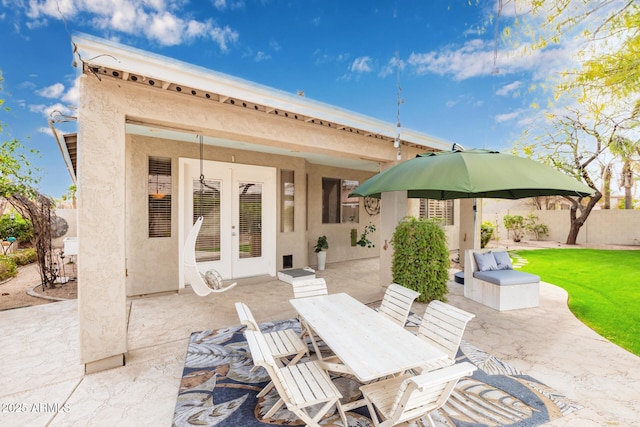 view of patio / terrace featuring french doors, outdoor dining area, and fence