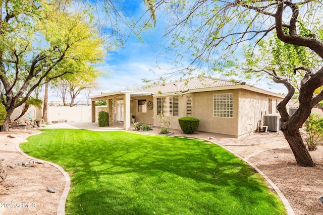 back of property with stucco siding, a lawn, a patio, fence, and cooling unit