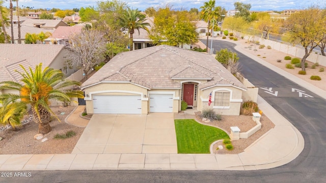 view of front of house featuring a garage, stucco siding, driveway, and a tile roof