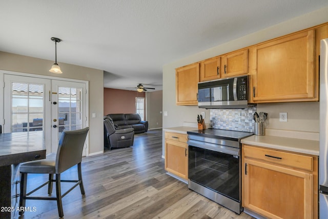 12720 W Cantenia Rd, Avondale, AZ 85392 - kitchen with appliances with stainless steel finishes, light wood-style flooring, ceiling fan, tasteful backsplash, and open floor plan