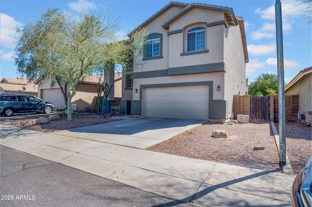 traditional-style house with stucco siding, fence, concrete driveway, a garage, and a tiled roof