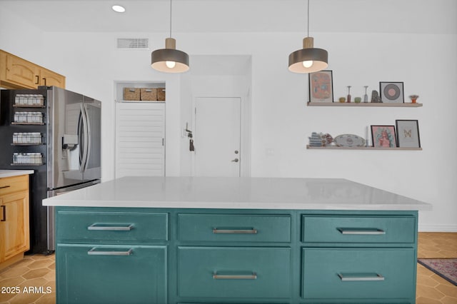 kitchen featuring open shelves, visible vents, stainless steel fridge, and pendant lighting