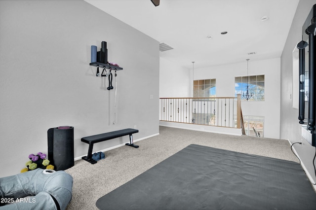 exercise area with a chandelier, visible vents, baseboards, and carpet floors