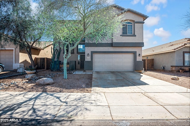 view of front of property with stucco siding, driveway, an attached garage, and fence