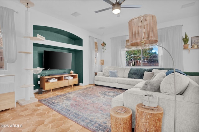 living room with ceiling fan with notable chandelier