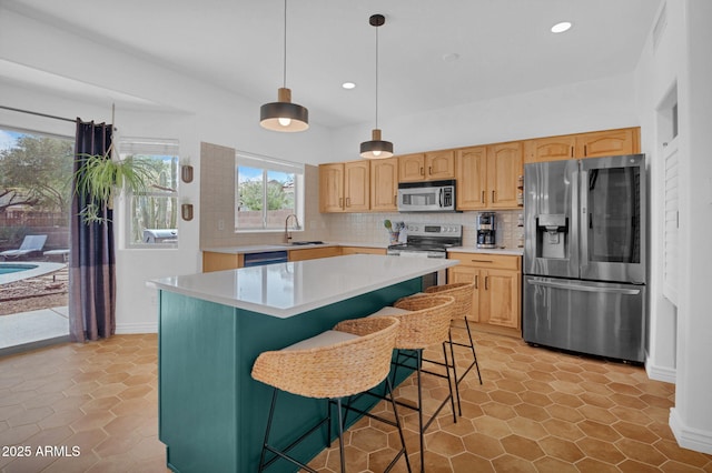 kitchen featuring a sink, decorative backsplash, appliances with stainless steel finishes, and light countertops