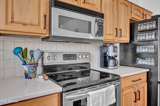 kitchen with decorative backsplash, light countertops, and stainless steel appliances