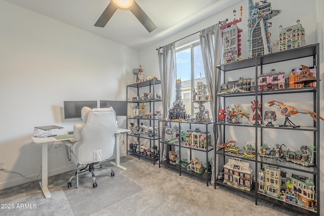 carpeted office with a ceiling fan and baseboards