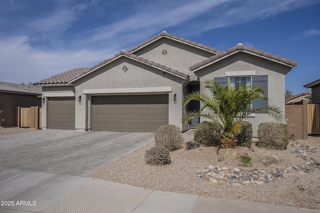 view of front of property with an attached garage, fence, driveway, a tiled roof, and stucco siding