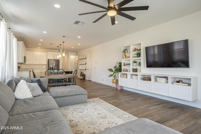 living area with baseboards, visible vents, dark wood-style flooring, and recessed lighting