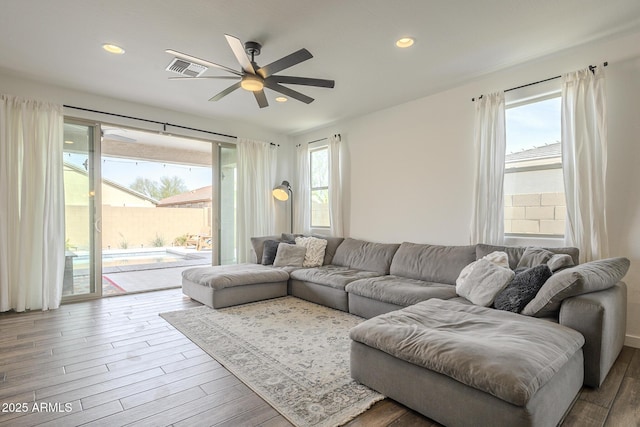 living room featuring recessed lighting, visible vents, and wood finished floors