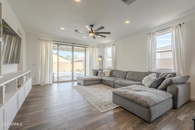 living room featuring dark wood-style flooring, plenty of natural light, and recessed lighting