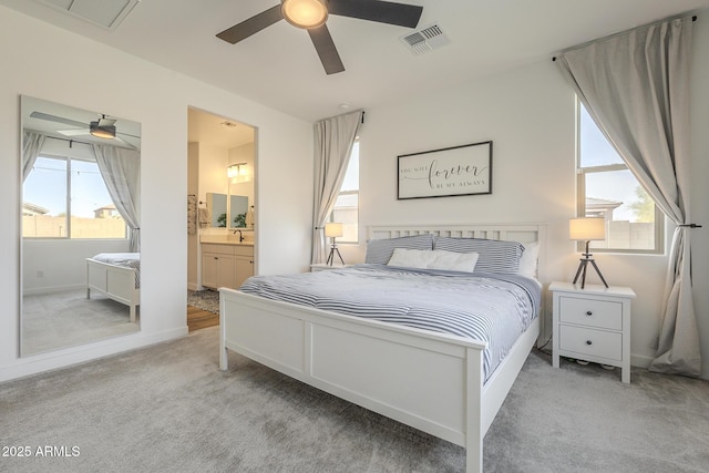 bedroom with carpet flooring, ceiling fan, visible vents, and ensuite bathroom