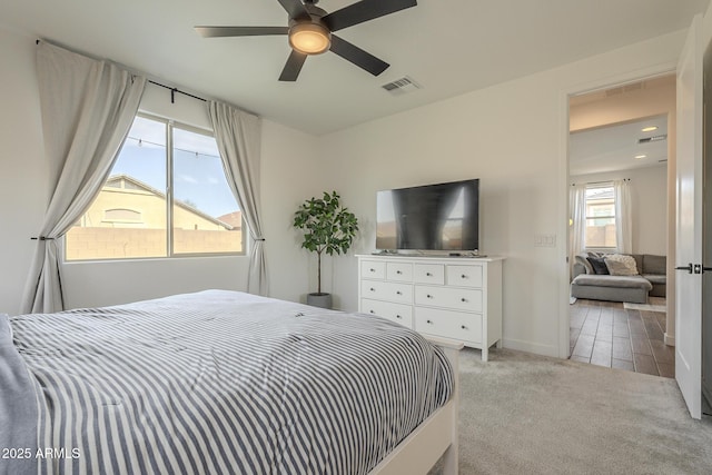 carpeted bedroom with baseboards, visible vents, and a ceiling fan