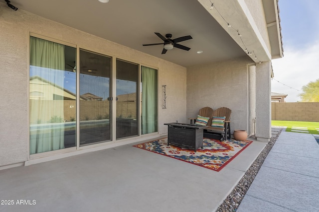 view of patio with ceiling fan and fence