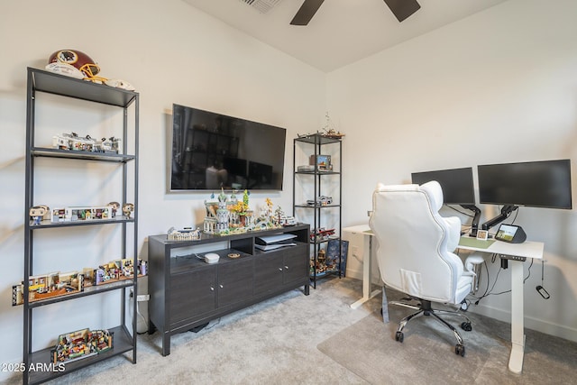 carpeted home office with ceiling fan and baseboards