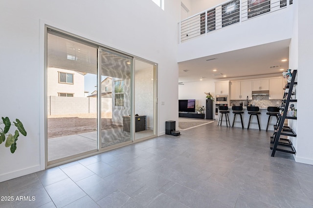 interior space with a high ceiling and baseboards