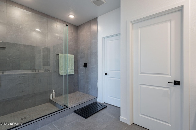 full bathroom featuring tile patterned flooring, walk in shower, and visible vents