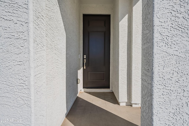 view of exterior entry with stucco siding