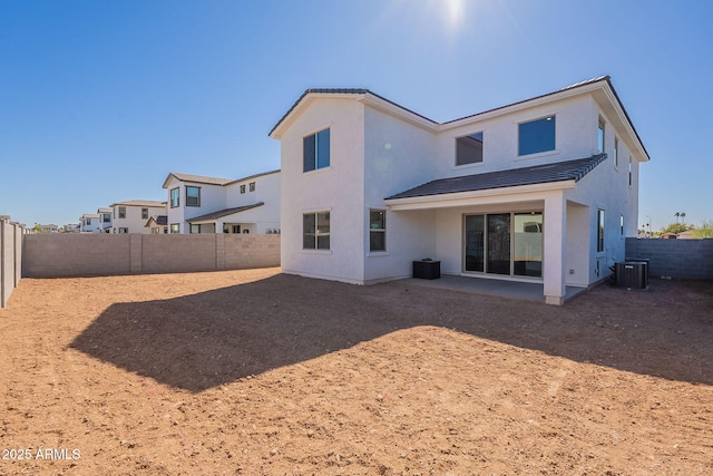 back of property with central air condition unit, a fenced backyard, and stucco siding