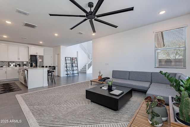 tiled living room featuring recessed lighting, visible vents, ceiling fan, and stairs