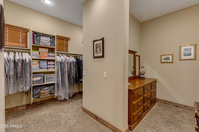 walk in closet with light colored carpet