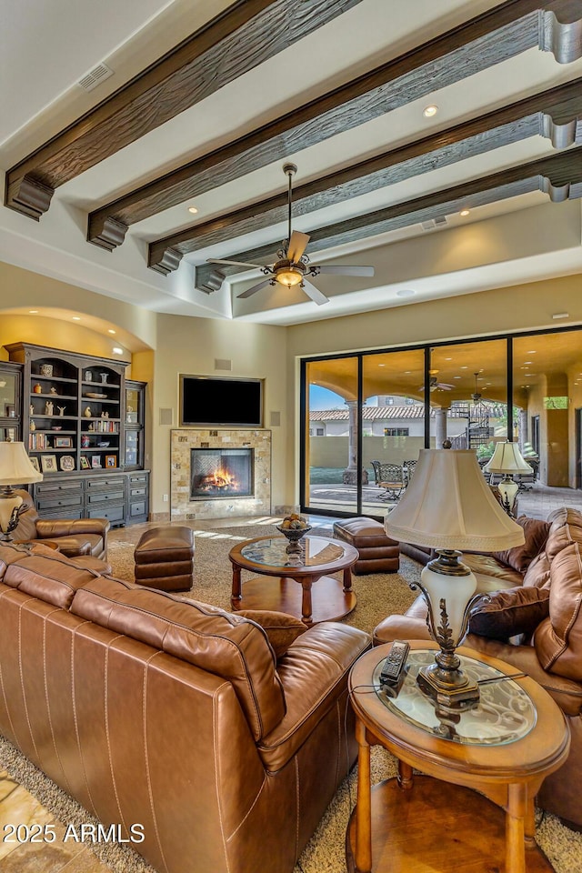 living room featuring ceiling fan and beamed ceiling