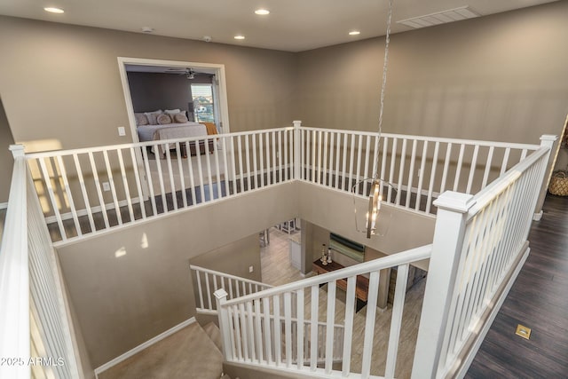 stairs featuring visible vents, a notable chandelier, and recessed lighting