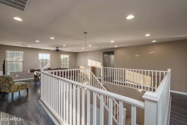 corridor with dark wood-style floors, recessed lighting, visible vents, and baseboards