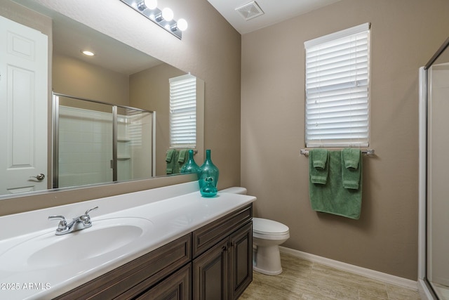 full bathroom featuring baseboards, visible vents, toilet, a shower with shower door, and vanity