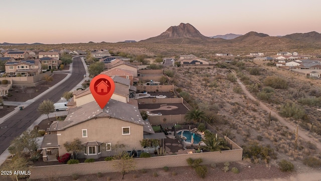 aerial view at dusk featuring a residential view and a mountain view