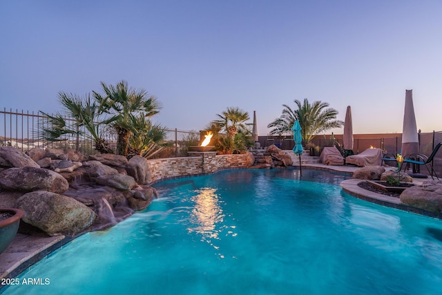 pool at dusk with fence and a fenced in pool