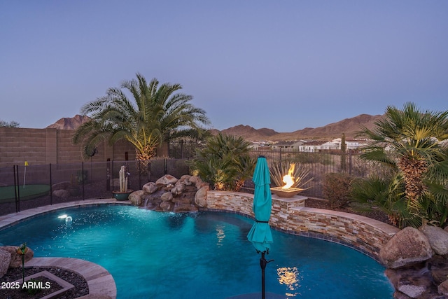 view of swimming pool with fence, a mountain view, and a fenced in pool