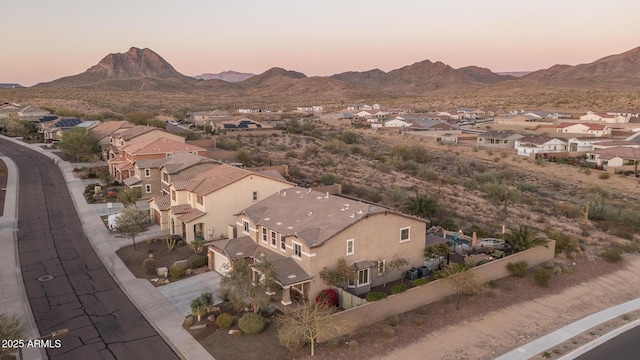 aerial view at dusk featuring a residential view and a mountain view