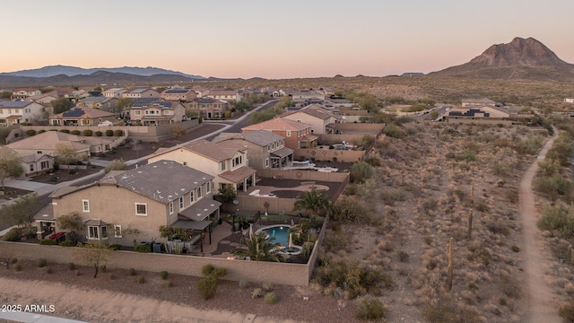 aerial view at dusk featuring a residential view and a mountain view