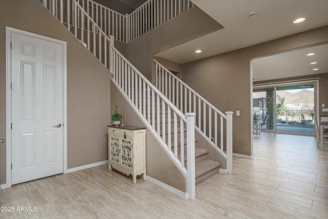 staircase with recessed lighting, baseboards, and wood finished floors