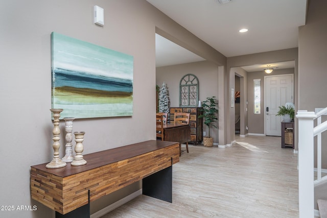 foyer entrance featuring light wood-style floors, baseboards, stairway, and recessed lighting