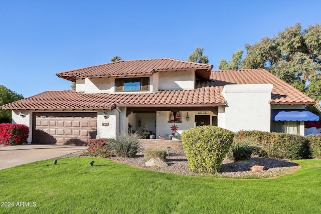 mediterranean / spanish home with a garage and a front lawn