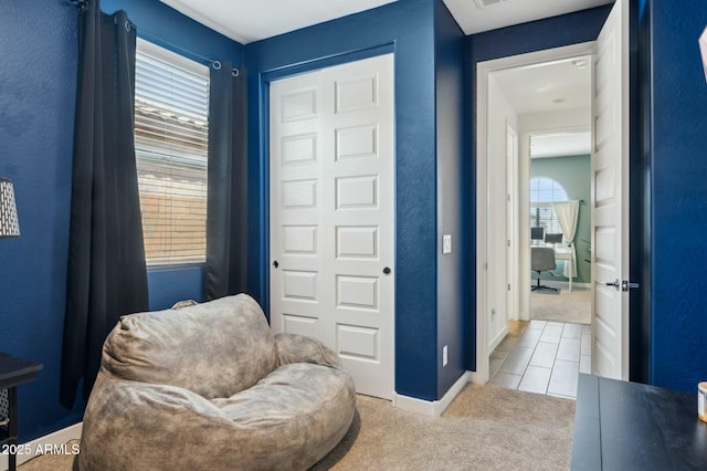 sitting room featuring tile patterned flooring, carpet floors, and baseboards