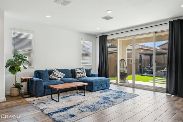 living area featuring visible vents, wood finished floors, and plenty of natural light