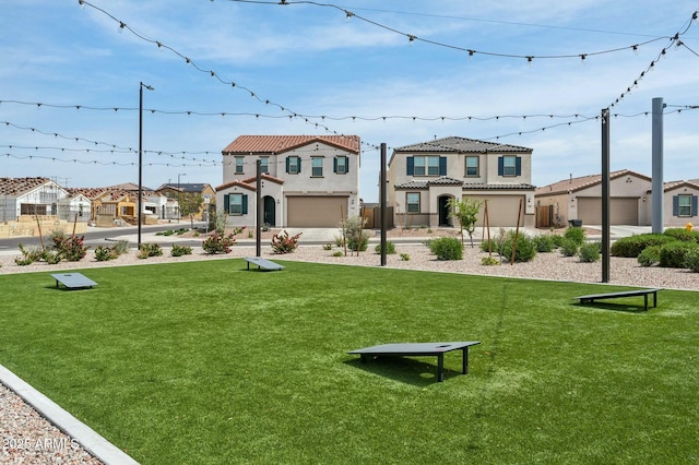 view of home's community with a lawn, an attached garage, driveway, and a residential view