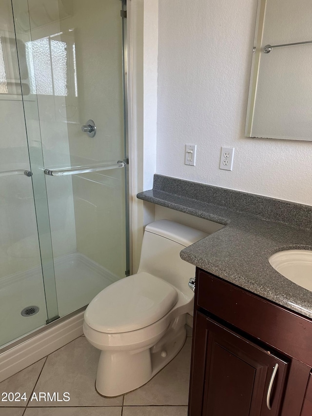 bathroom featuring tile patterned floors, vanity, toilet, and walk in shower