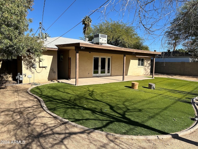 back of property with a patio area, central AC, a yard, and french doors