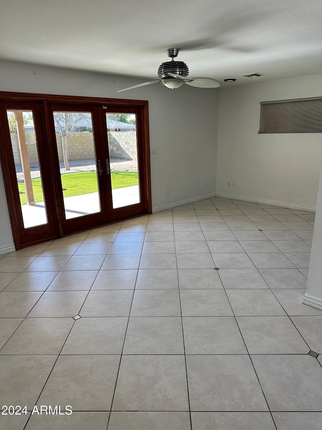 tiled spare room with ceiling fan and french doors