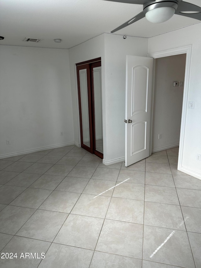 tiled spare room with ceiling fan