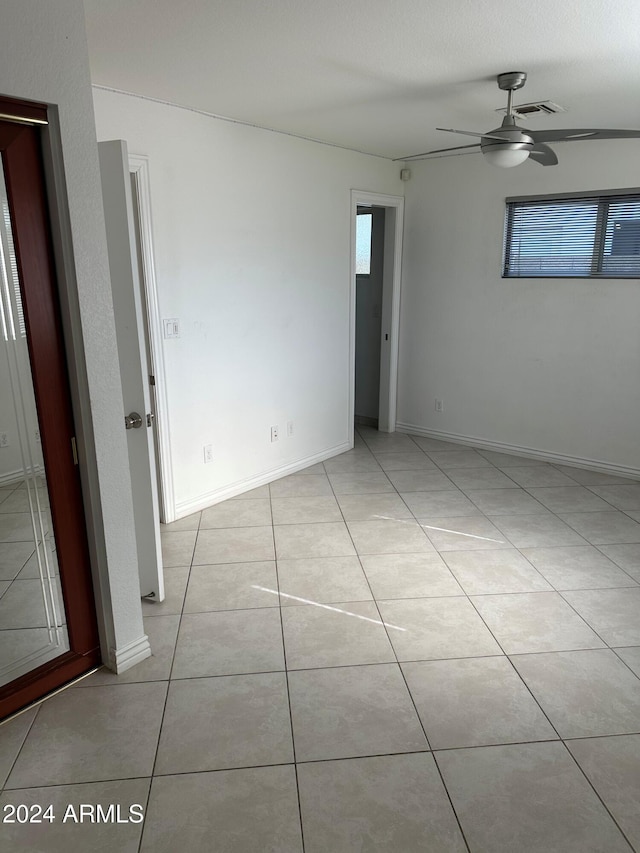 unfurnished room featuring ceiling fan and light tile patterned flooring