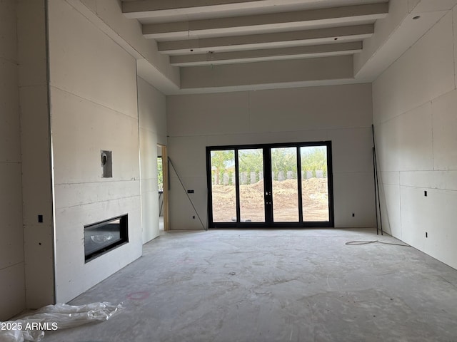 6426 E Turquoise Ave, Paradise Valley, AZ 85253 - unfurnished living room with concrete flooring, a towering ceiling, french doors, and a fireplace
